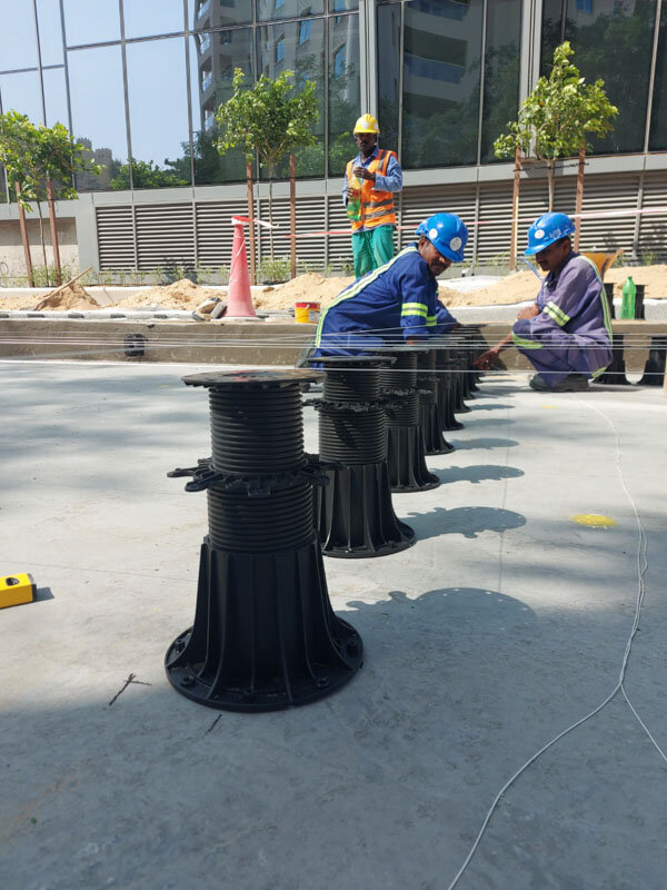 Leveling terrace pedestals on the construction site.