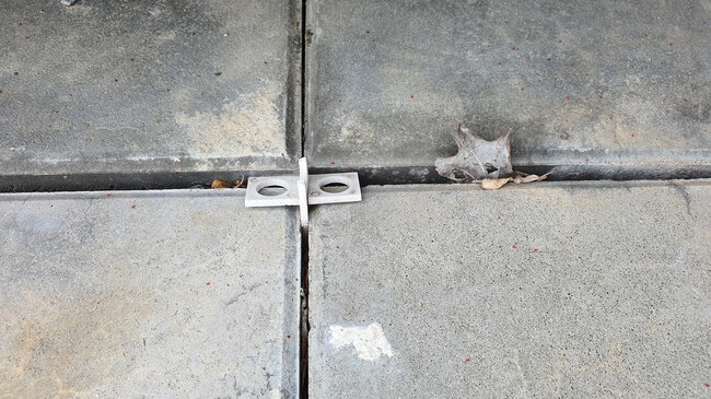 Plastic spacer cross for laying pavers on the terrace.