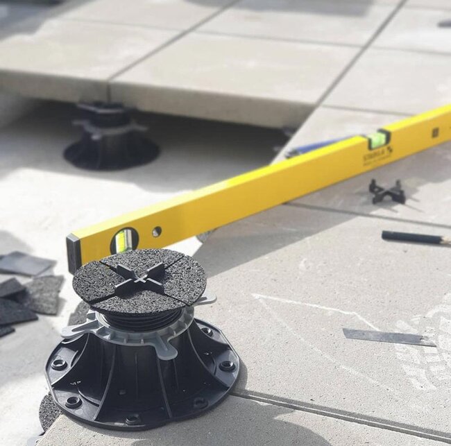 Adjustable terrace pedestal for pavers with a level