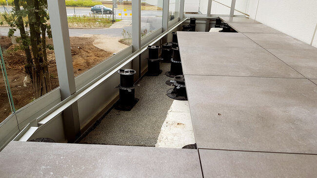 Balcony with gres tiles on pedestals with a step and a large height difference