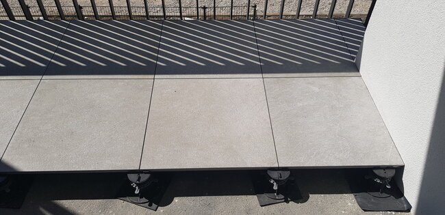 Ceramic gres pavers on standard adjustable pedestals solver on balcony