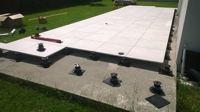 Terrace on ground on concrete slab laid on adjustable pedestals