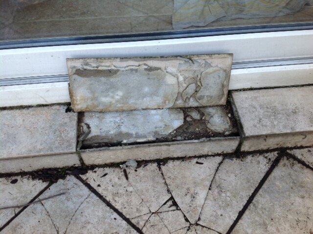 Delaminated paver and cracked paver on a traditional adhesive terrace