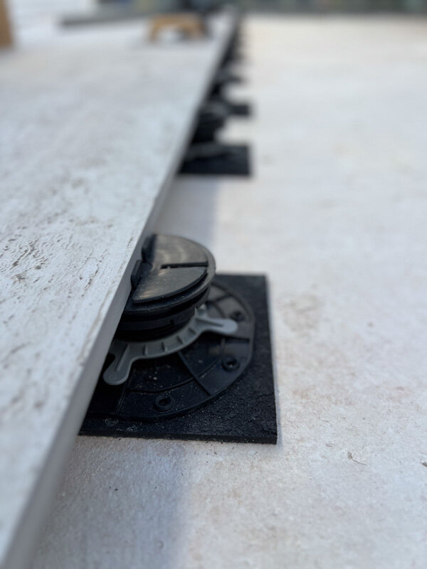 Terrace pedestal on SBR rubber pad with SH rubber shim under the paver