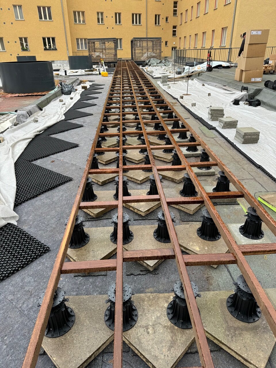 Construction of a raised deck terrace frame from joists on adjustable pedestals