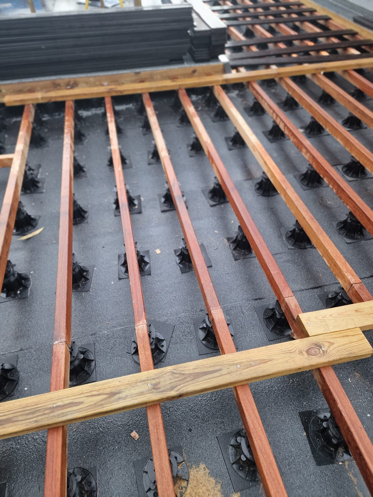 Installation of wooden joists on adjustable pedestals on the roof