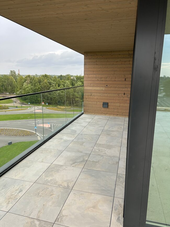 Modern balcony terrace installed with outdoor porcelain pavers on an adjustable pedestal system.