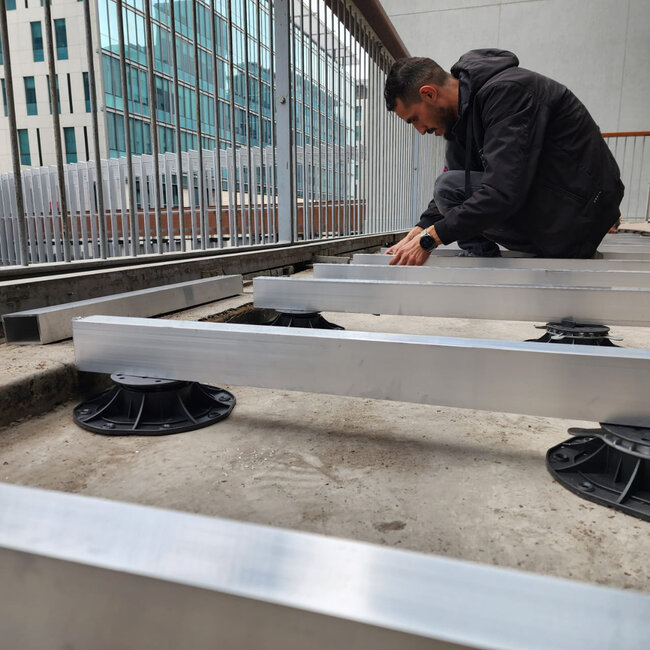 Installation of aluminum joists supported by adjustable plastic pedestal risers for a terrace deck