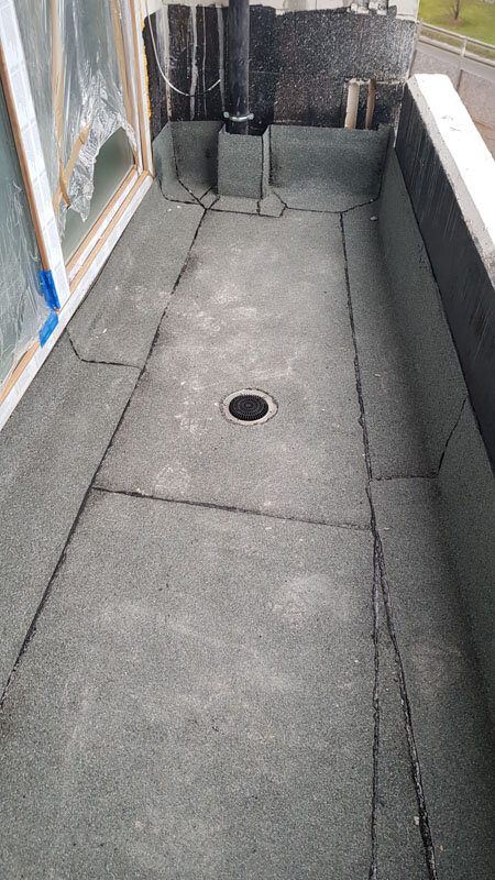 Concrete balcony floor with waterproofing membrane and a central drainage outlet