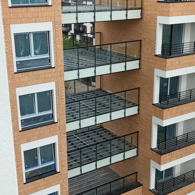 Multi story balcony sub frames featuring aluminum joists supported by adjustable plastic deck pedestals.