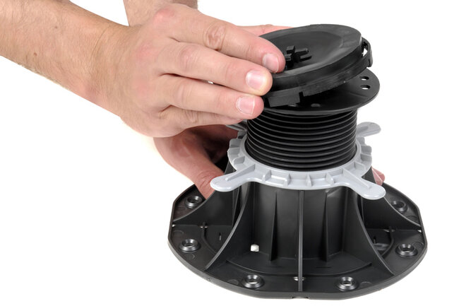 Adjusting an adjustable plastic pedestal riser for decking or subfloor levelling.