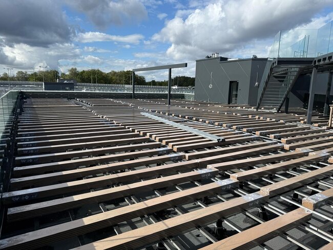 Aluminum joist substructure on pedestal mounts being installed for a modern rooftop deck.