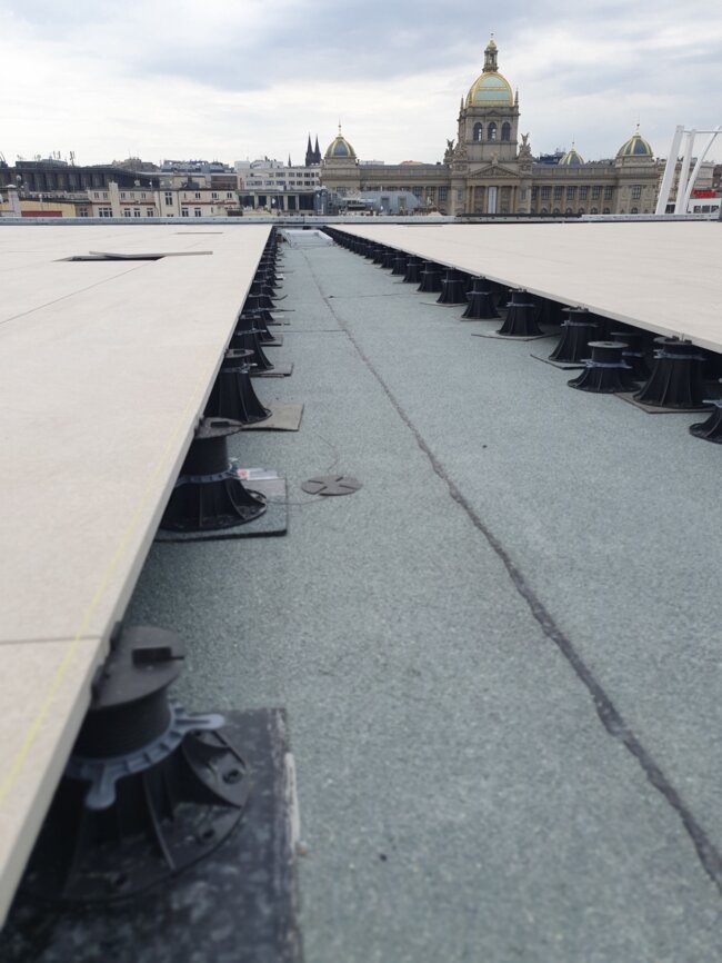 Rooftop terrace porcelain paver installation using adjustable pedestal supports.