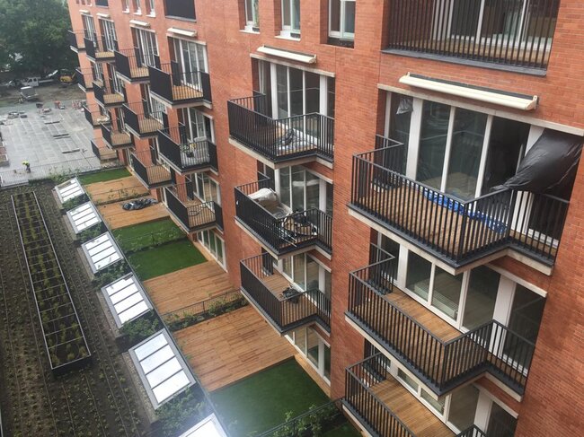 Modern multi-story residential building featuring timber decking on apartment balconies.