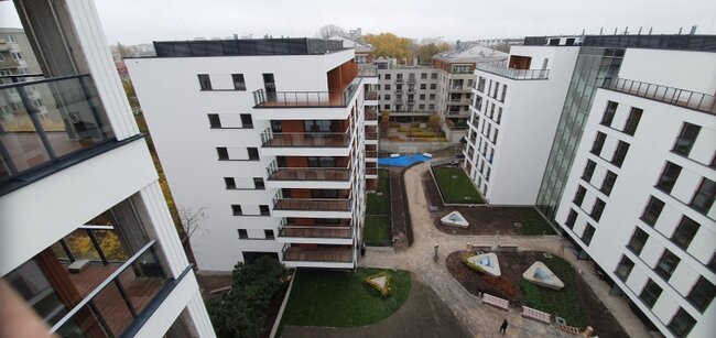 Aerial high-angle view of a modern residential apartment complex with balconies and landscaped courtyards.