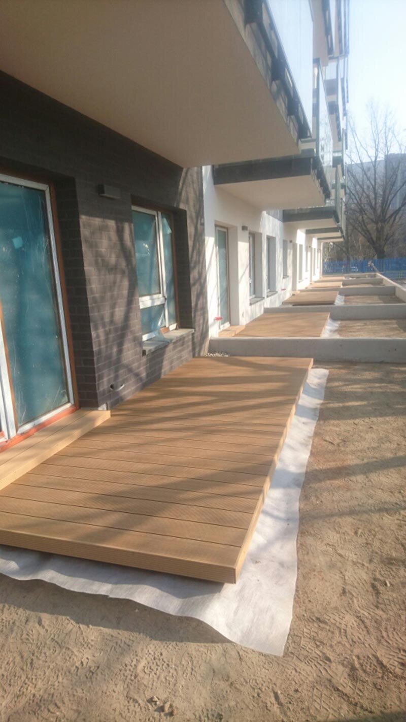 Newly constructed composite decking platforms outside residential ground-floor units.