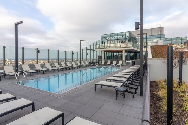 Rooftop swimming pool deck with raised pavers on adjustable pedestals.
