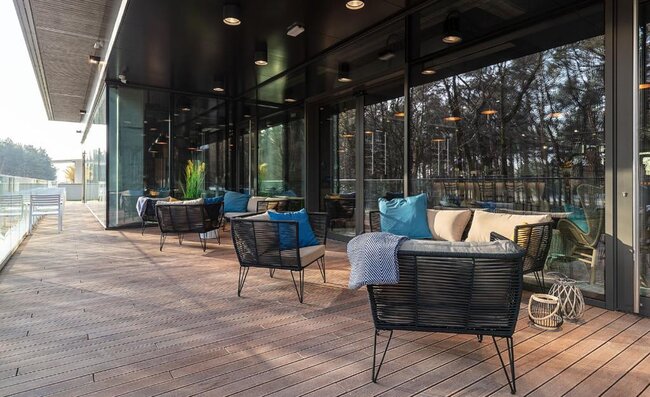 Modern outdoor lounge seating arranged on a clean raised wooden terrace deck.