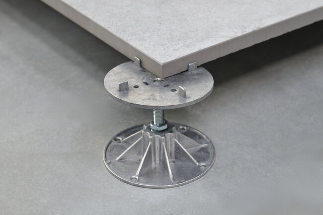 Adjustable pedestal system supporting raised floor tile for high-rise fire safety compliance.