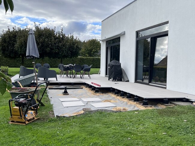 Modern house patio installation featuring outdoor tile pavers raised on adjustable pedestals.