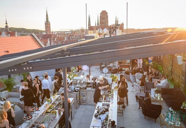 Commercial rooftop lounge built on an adjustable pedestal paver system during sunset event.