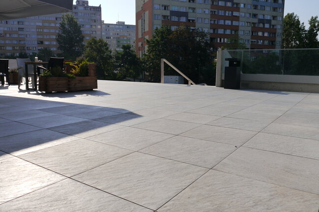 Flat roof terrace paver system installed on adjustable pedestal supports.