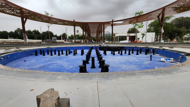 Adjustable pedestals installed across a blue tiled fountain basin for an outdoor water feature raised floor system.