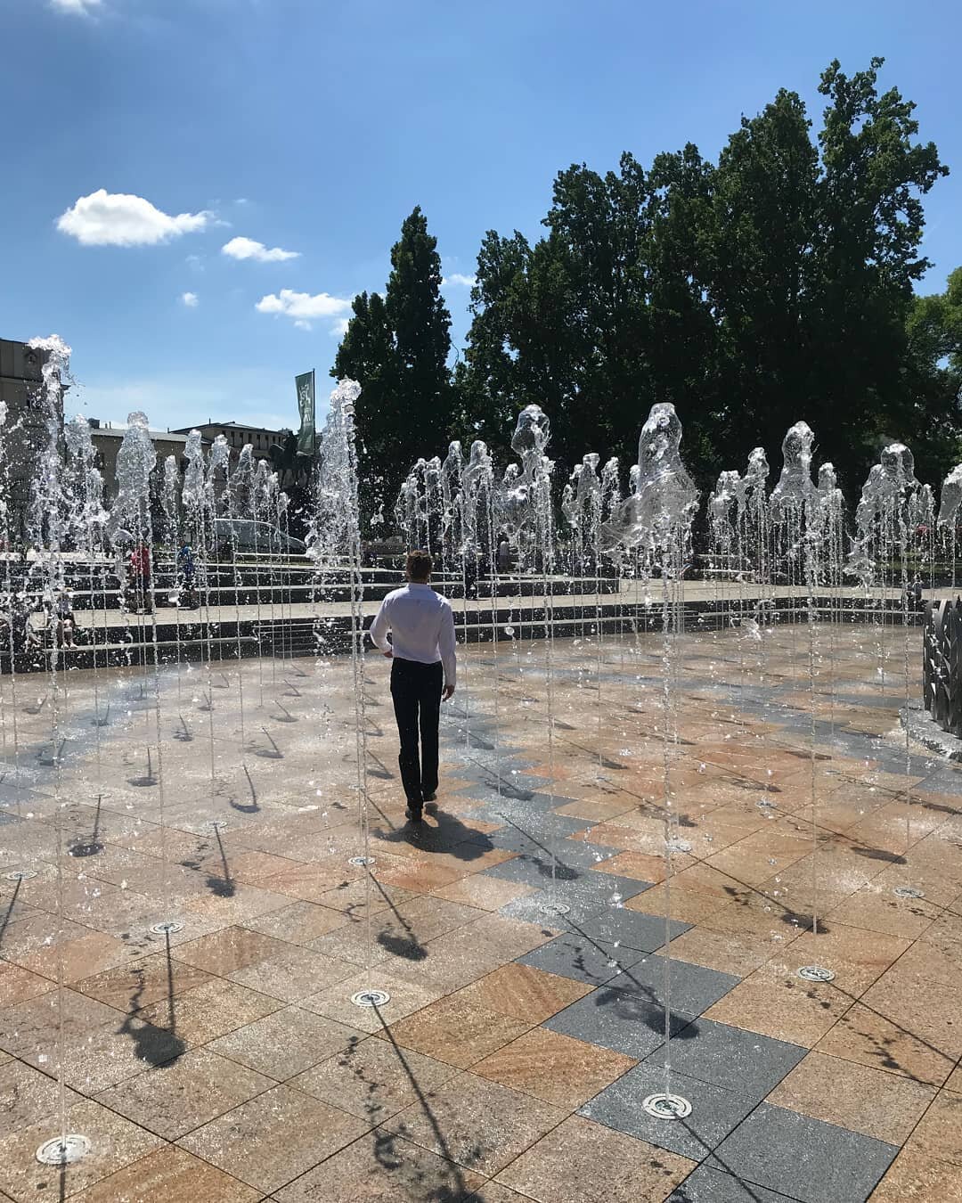 Completed outdoor dry deck fountain with integrated nozzles installed over an adjustable pedestal raised paver system.